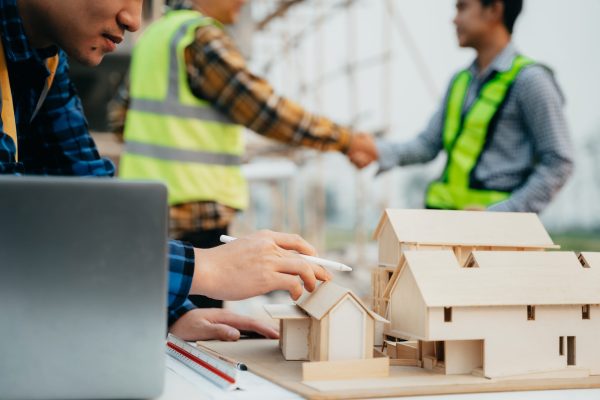 Engineer Teamwork Meeting, Drawing working on blueprint meeting for project working with partner on model building at construction site. Asian industry professional team